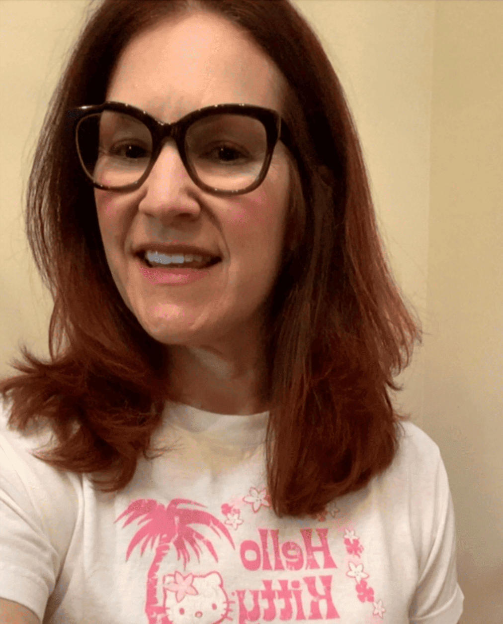 Selfie of a redheaded woman wearing glasses and a Hello Kitty shirt